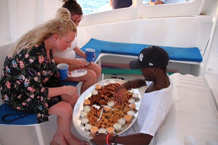 People on a boat with a tray of food and drinks. 2