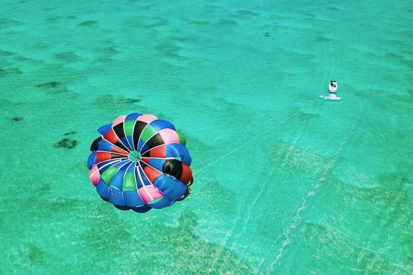 A person parasailing over turquoise water. 4