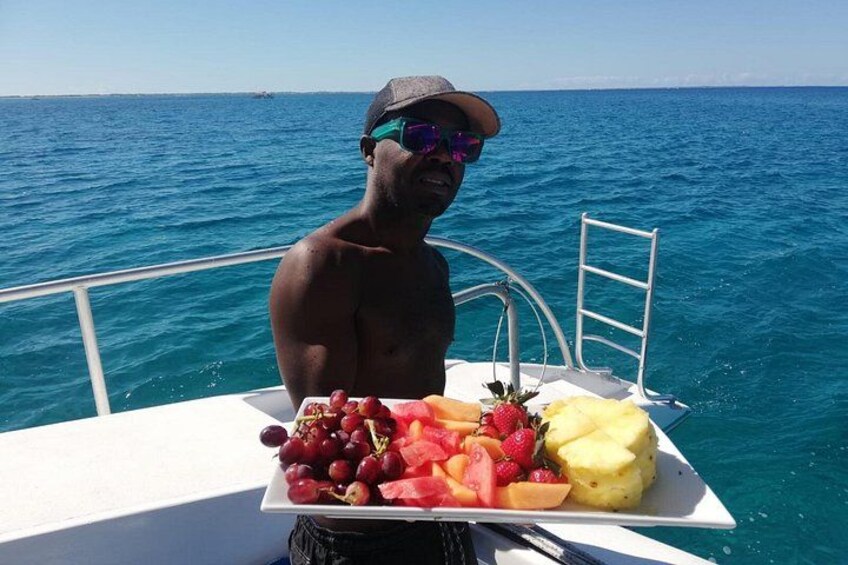 Una persona en un barco sosteniendo un plato de fruta. 5