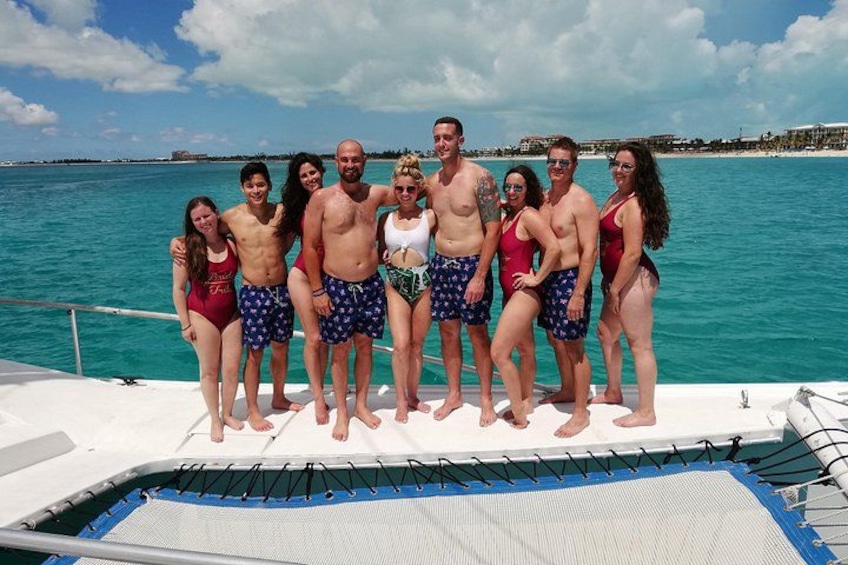 A group of people on a boat with a clear blue sea and a distant shoreline in the background. 3