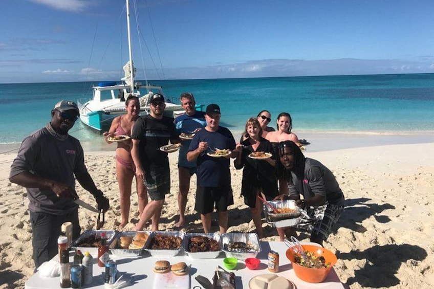 A group of people on a beach with a boat in the background. 2