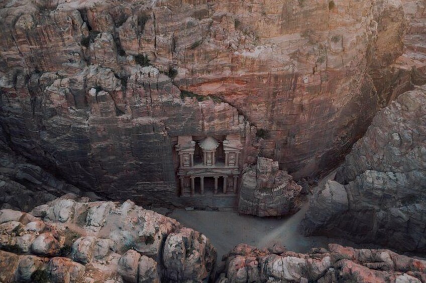 A rock-cut temple with a central shrine, surrounded by rugged cliffs. 2