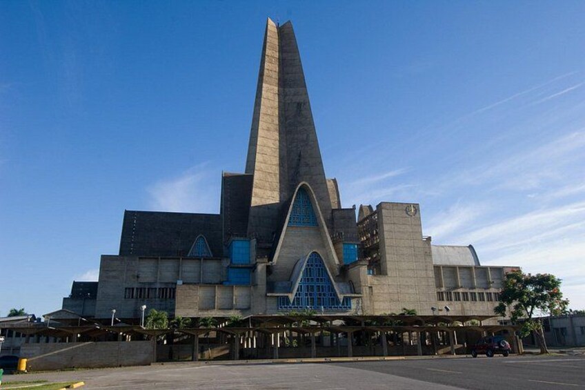 Un edificio grande y moderno con una imponente torre central y una entrada azul. 1