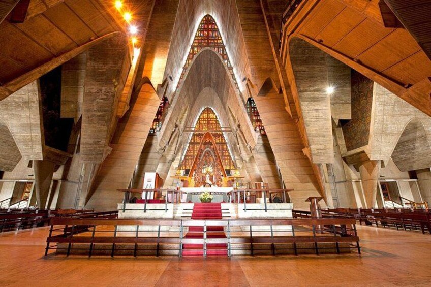 A large cathedral interior with high vaulted ceilings and a central altar. 2