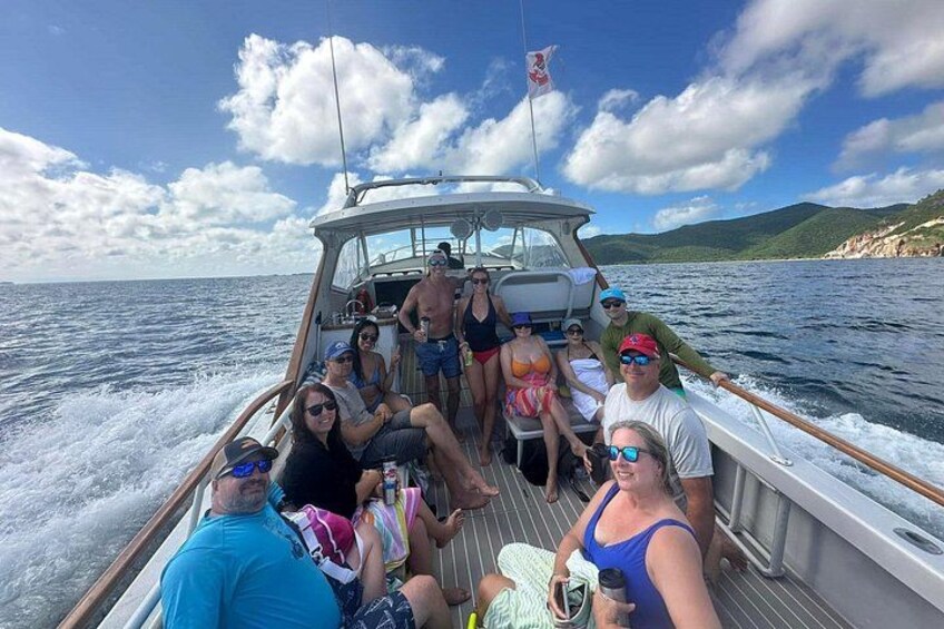 Un grupo de personas en un bote, con una bandera, agua y tierra a lo lejos. 4