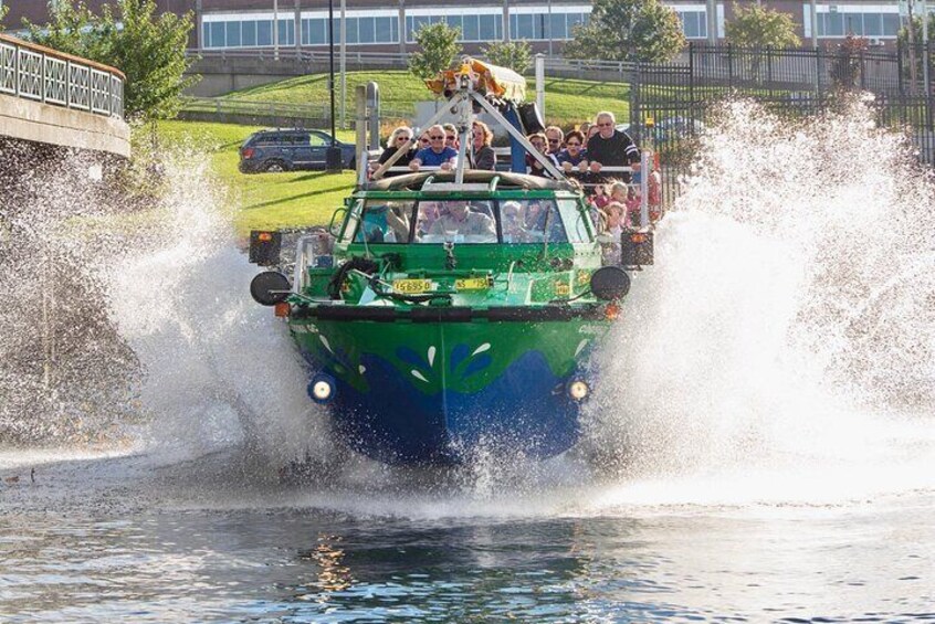 Un bateau vert avec des personnes à bord qui éclaboussent de l’eau. 5
