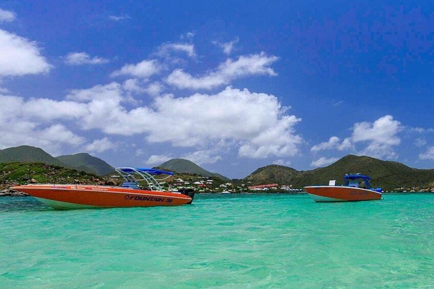 Two boats on turquoise water with mountains in the background. 3