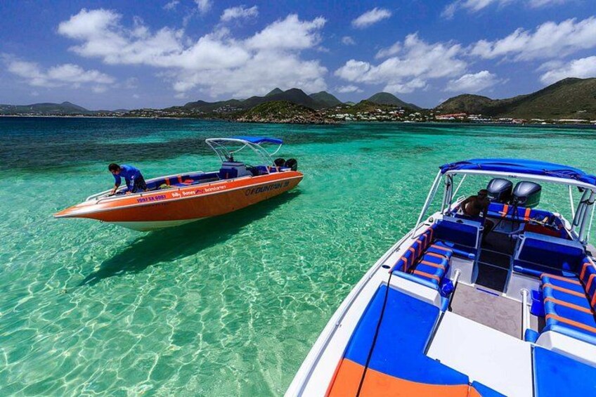 Two boats on clear turquoise water with a mountainous landscape in the background. 4