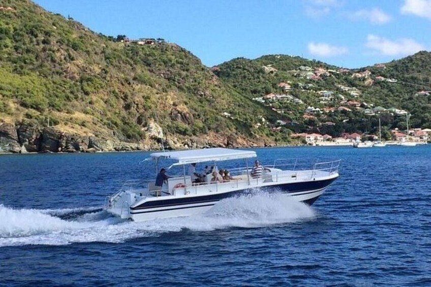 A speedboat on a calm sea with a hilly coastline in the background. 4