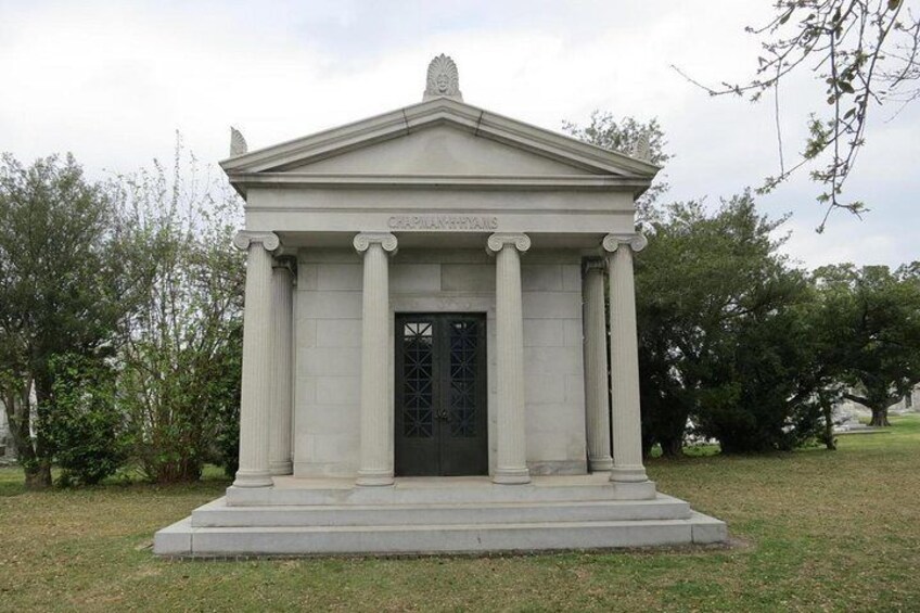 A neoclassical building with columns and a pediment, surrounded by trees. 3