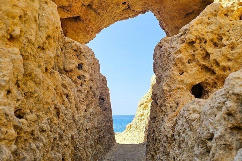 A natural rock formation with an archway leading to the sea. 3