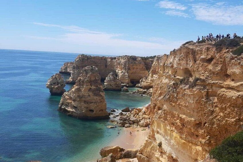 A coastal landscape with rocky cliffs and clear blue waters. 2