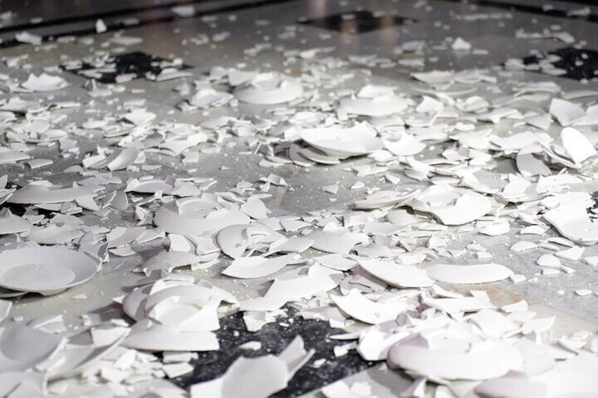 Broken ceramic pieces on a floor. 1