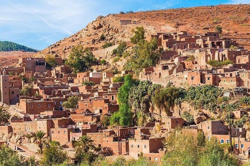A village with terracotta-roofed buildings nestled in a hilly landscape. 5