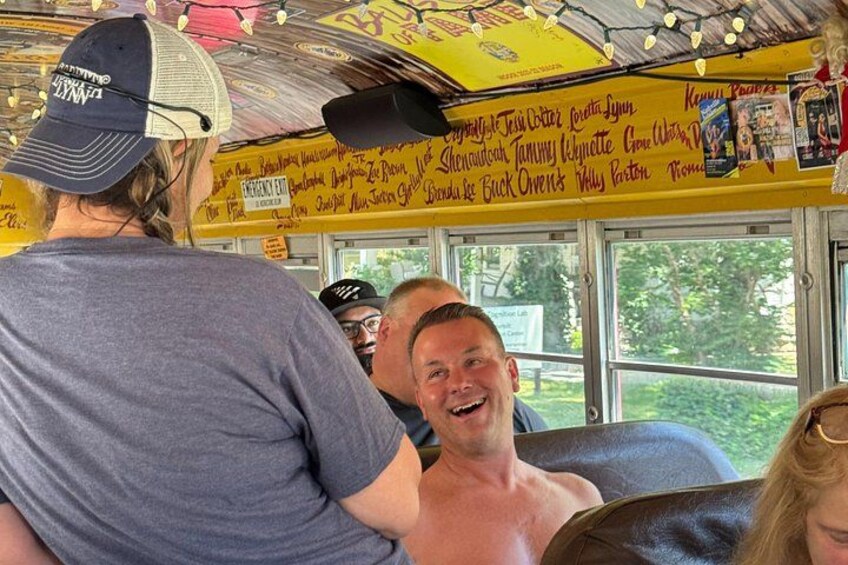 L'intérieur d'un autobus avec des passagers assis, un plafond jaune et un panneau affichant le menu avec les différents plats proposés. 2