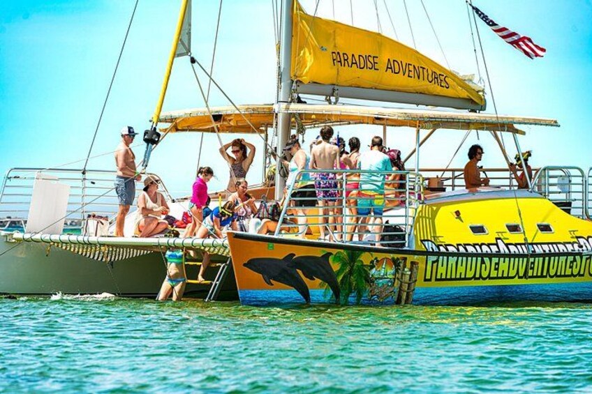 A boat with people on board, a yellow canopy, and a flag. 4
