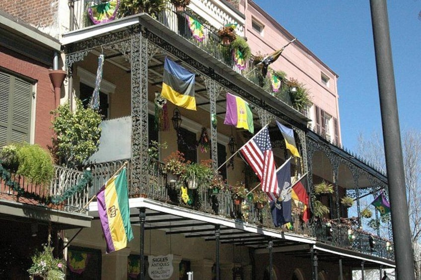 A building with balconies adorned with flags and plants. 2
