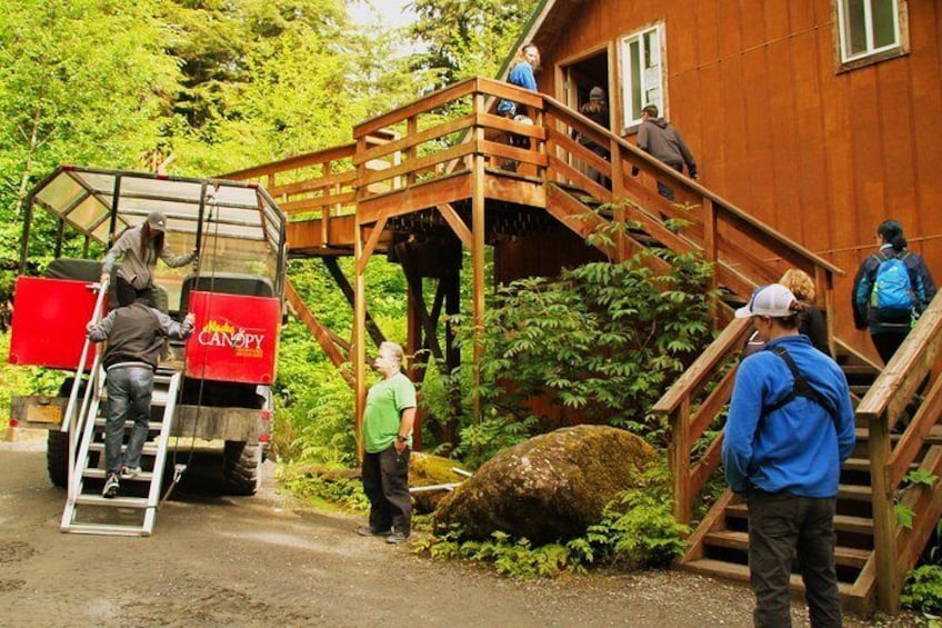 A wooden staircase leading to a house surrounded by greenery. 2