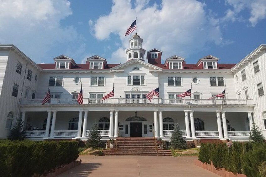 A large white building with multiple American flags, a central tower, and a symmetrical facade. 2