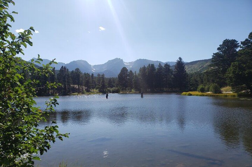 A calm lake with mountains in the background and a clear sky. 2