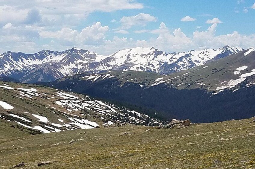 A mountainous landscape with snow-capped peaks, a valley, and a clear sky. 3