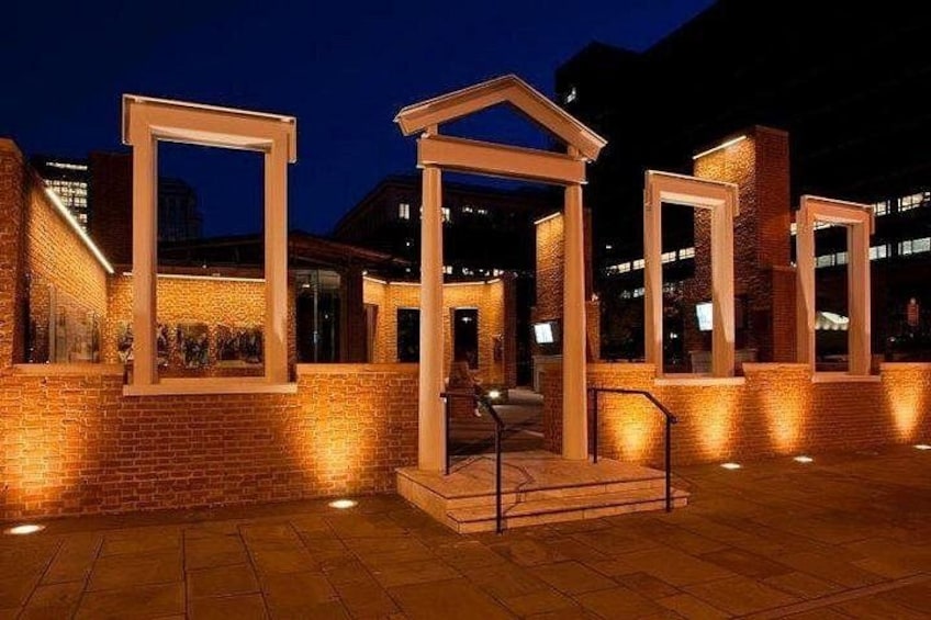Un edificio in mattoni con cornici illuminate e una ringhiera metallica. 5
