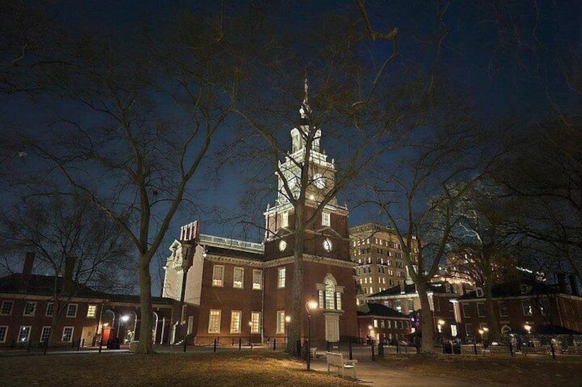 A historic building with a clock tower, surrounded by trees and illuminated by street lamps. 3