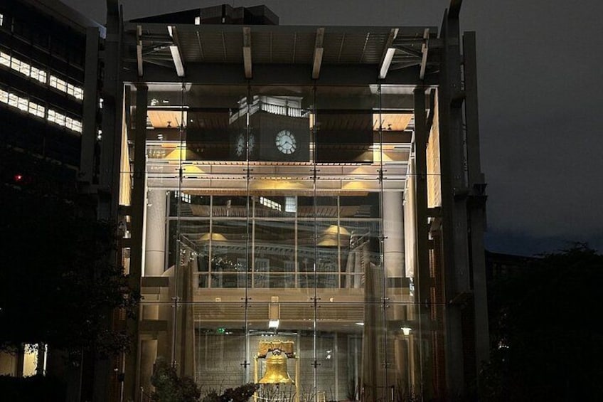 Un edificio moderno con una grande facciata vetrata, una torre dell'orologio e una statua dorata all'ingresso. 4