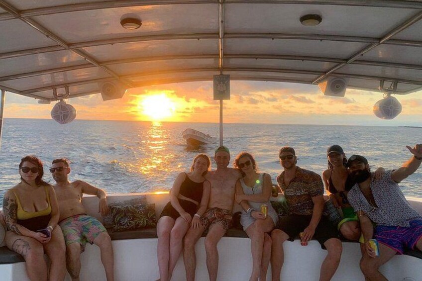 A group of people on a boat during sunset. 2