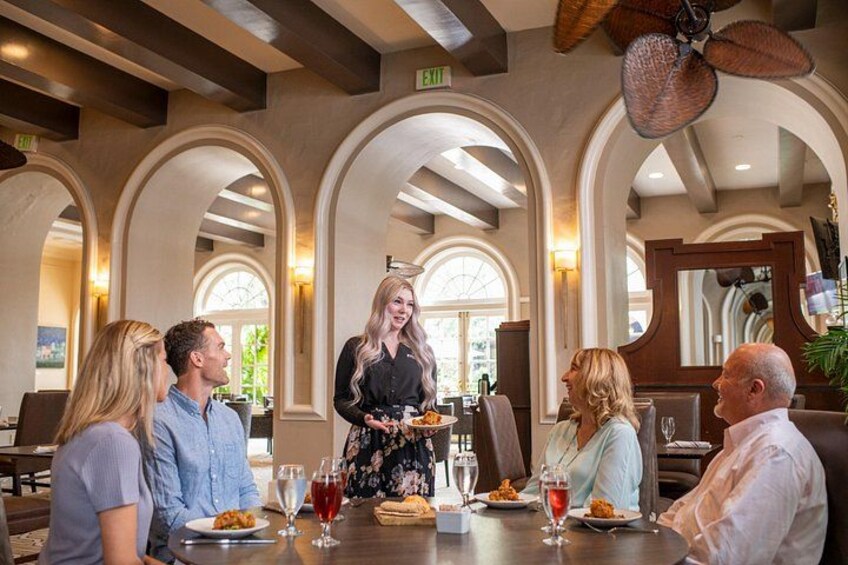 A group of people dining in a restaurant with arched ceilings and a large fan. 4
