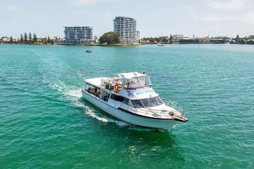 Un bateau blanc sur lequel on peut lire les mots « SEA WATCH » sur le côté, naviguant dans une eau turquoise, avec des bâtiments en arrière-plan. 2