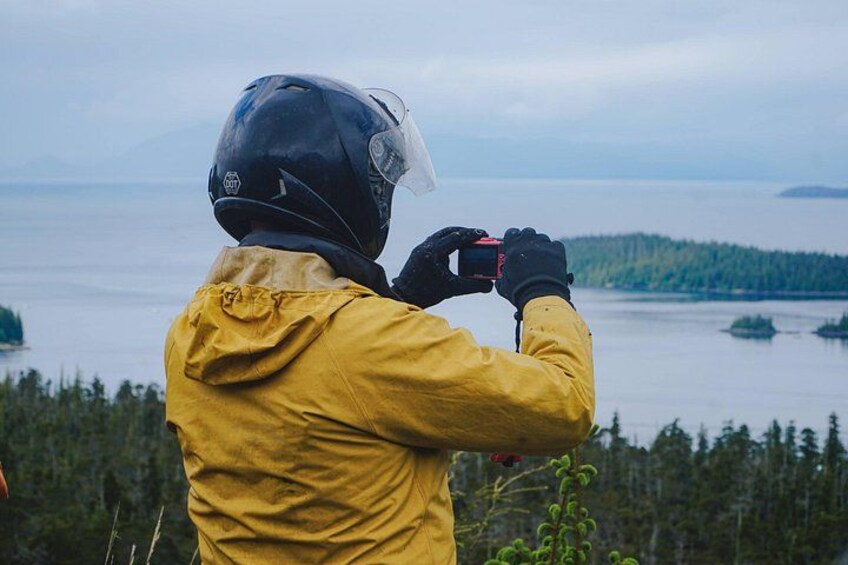 A person in a yellow jacket taking a photo with a camera. 4