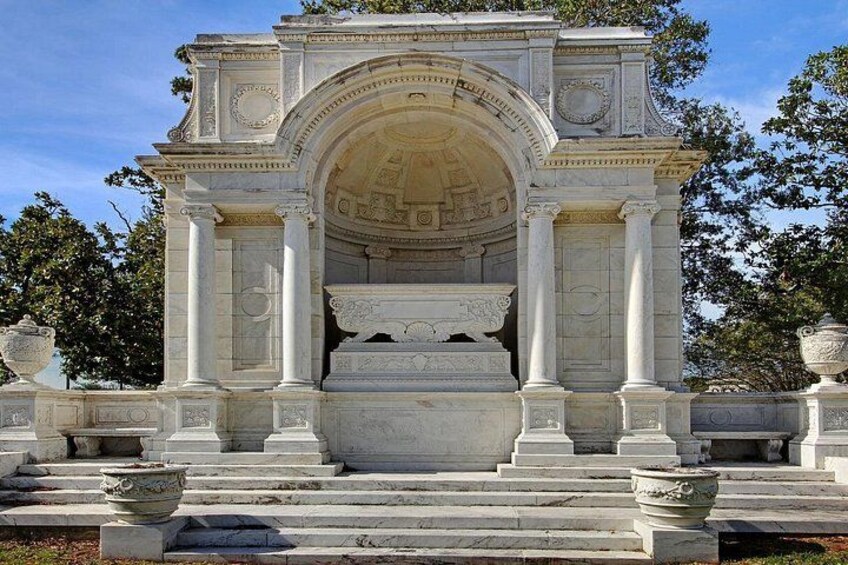 Een klassiek monument met kolommen en een boogvormige ingang. 3