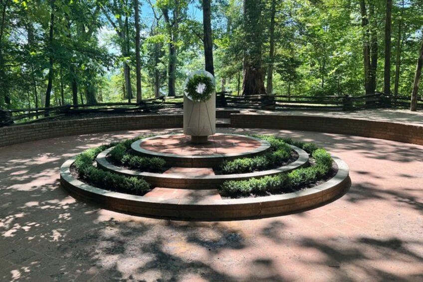A circular garden with a central statue, surrounded by a brick pathway and lush greenery. 3