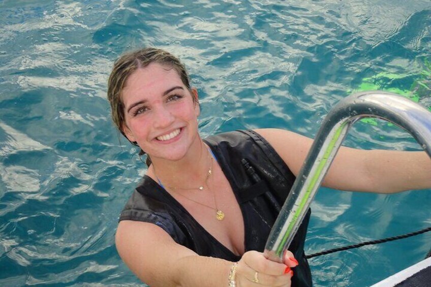 Une personne vêtue d’un maillot de bain noir, tenant le volant d’un bateau. 4