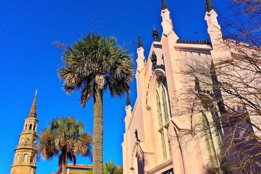A church with a tall spire and palm trees. 4