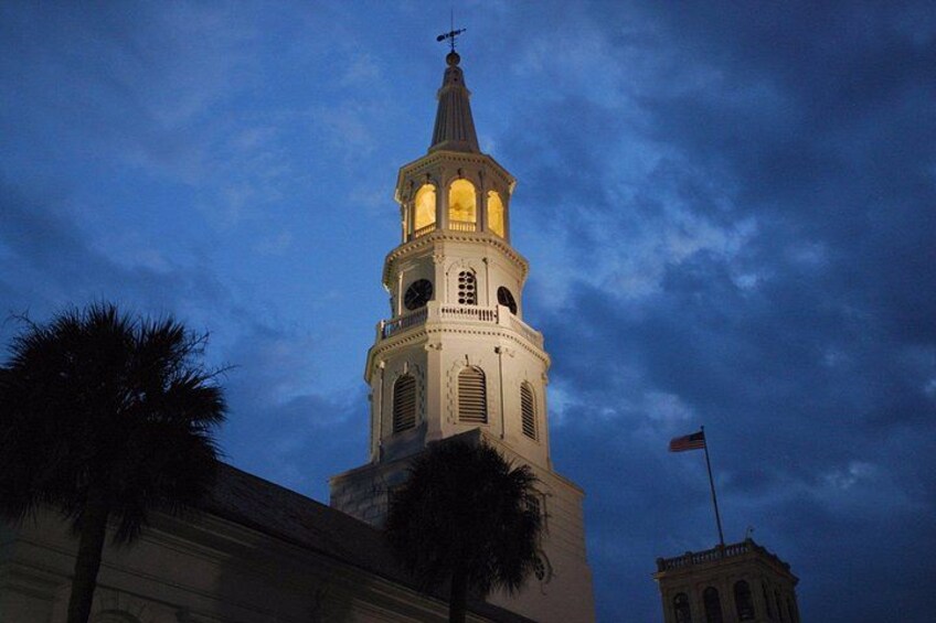 A church tower with a clock, under a dark sky. 1