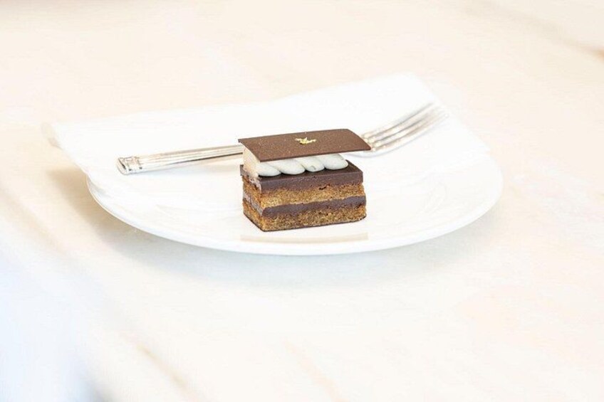 A slice of cake on a white plate with a fork beside it. 2