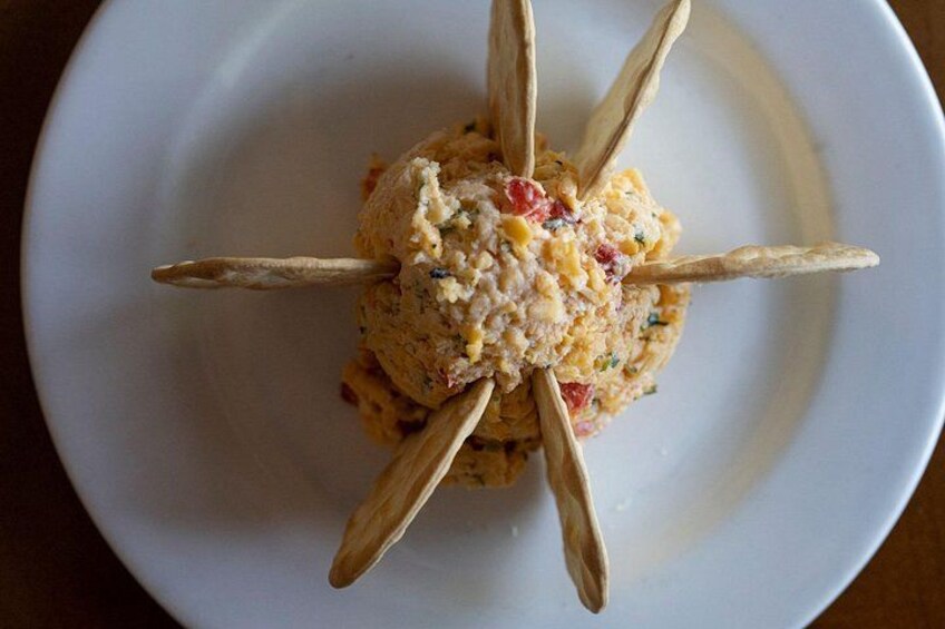 A white plate with a central food item surrounded by wooden skewers. 4