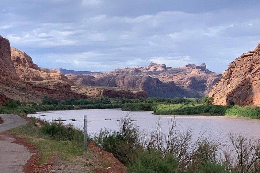 Un fiume circondato da ripide scogliere rocciose, un cielo sereno e una vegetazione rada. 2