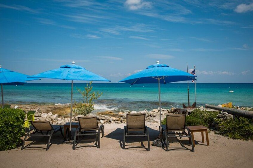 Ein Strand mit Liegestühlen und blauen Sonnenschirmen. 5