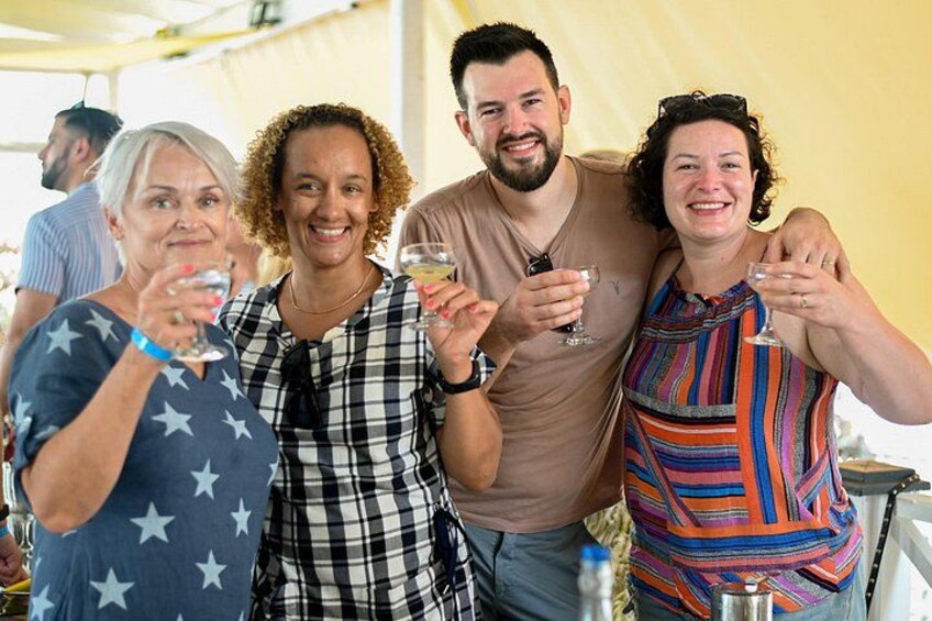 A group of people toasting with drinks at an outdoor event. 3