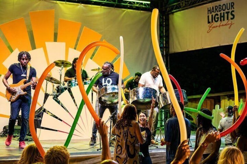 A band performing on stage with colorful streamers, a drummer, and a guitarist. 2