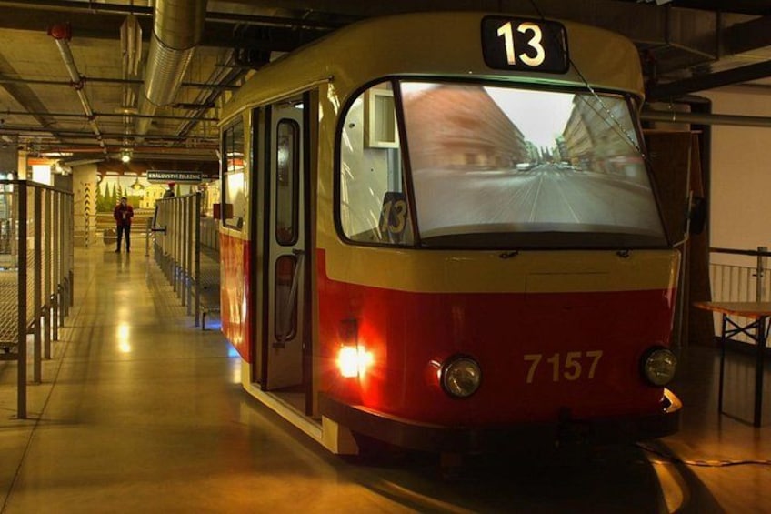 A train with the number 13 and 7157 on it, stationary at a platform. 4