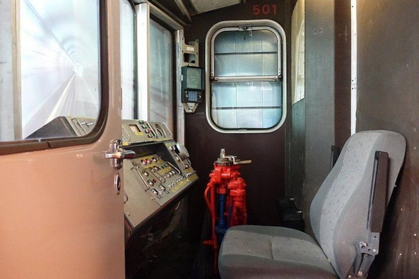 A train control panel, a window, and a seat. 2