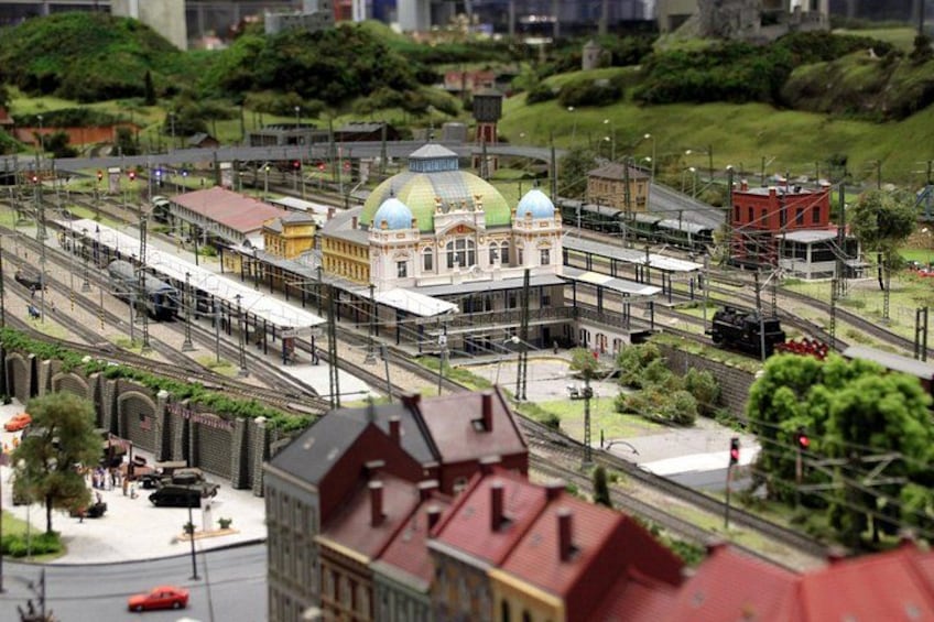 A model train layout with a station, tracks, and surrounding buildings. 1