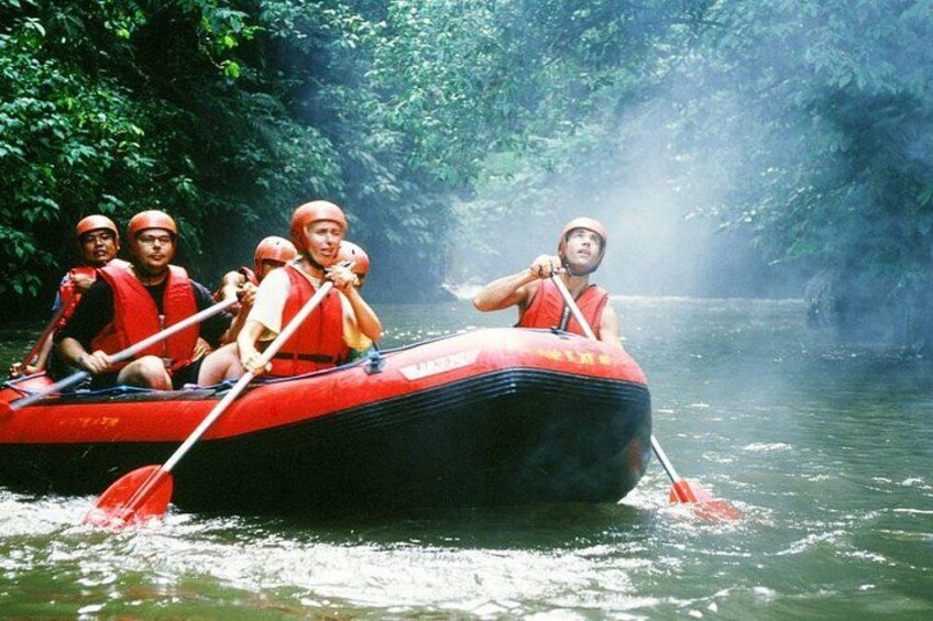 A group of people in a red raft on a river surrounded by dense greenery. 4