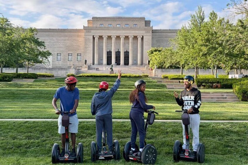 Cuatro personas en segways frente a un edificio grande con columnas. 5