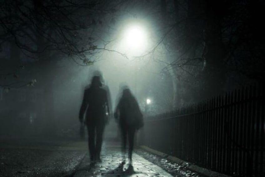 Une rue brumeuse, de nuit, avec une lumière vive au loin. 3