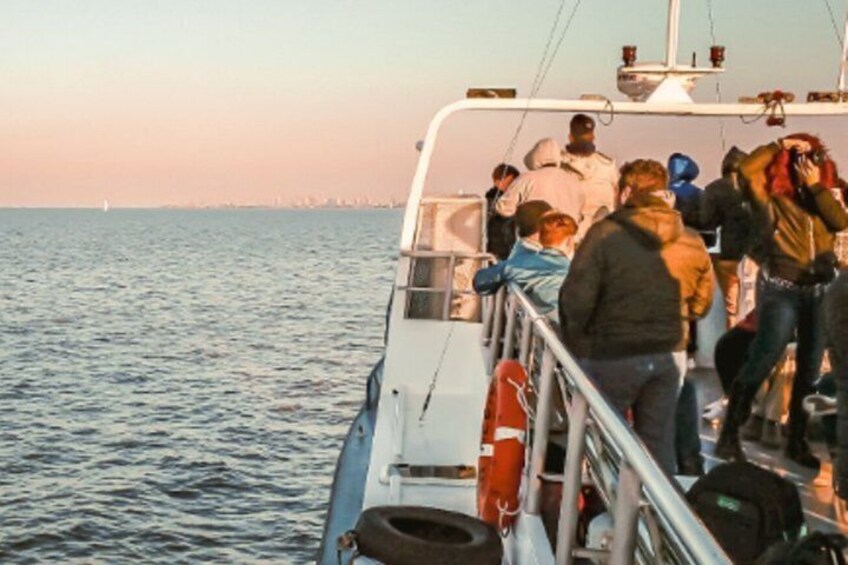People on a boat with a city skyline in the background. 3